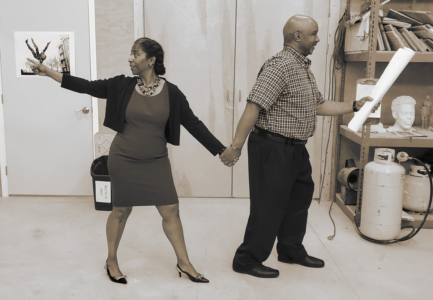Reference photo: woman pointing, man holding plans, holding hands